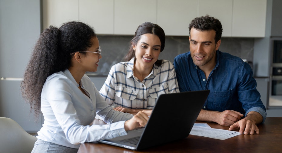 A financial advisor speaks with a woman and man.